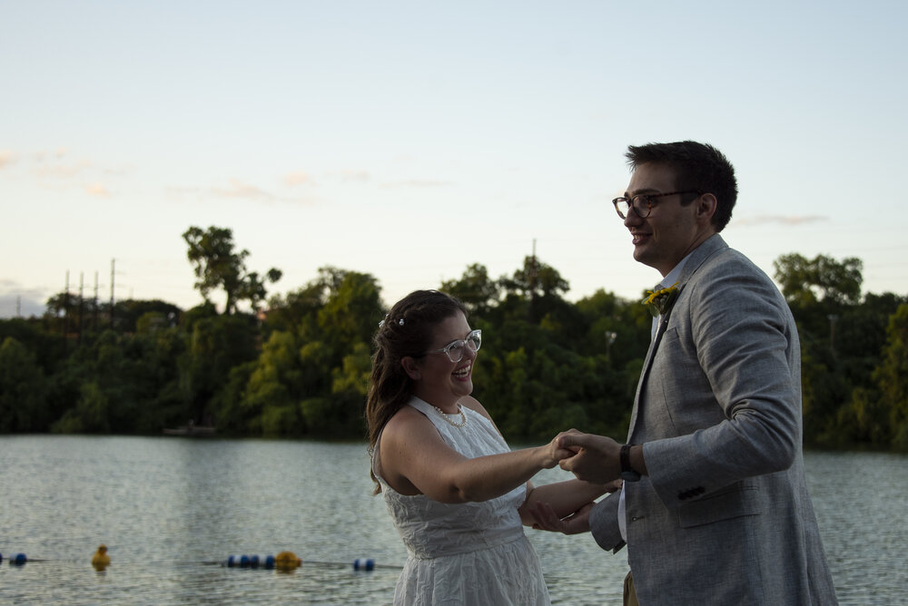 Documentary wedding photograph of an adventurous bride and groom’s first dance at their intimate wedding on the Rowing Dock on Lady Bird Lake across from downtown Austin.
