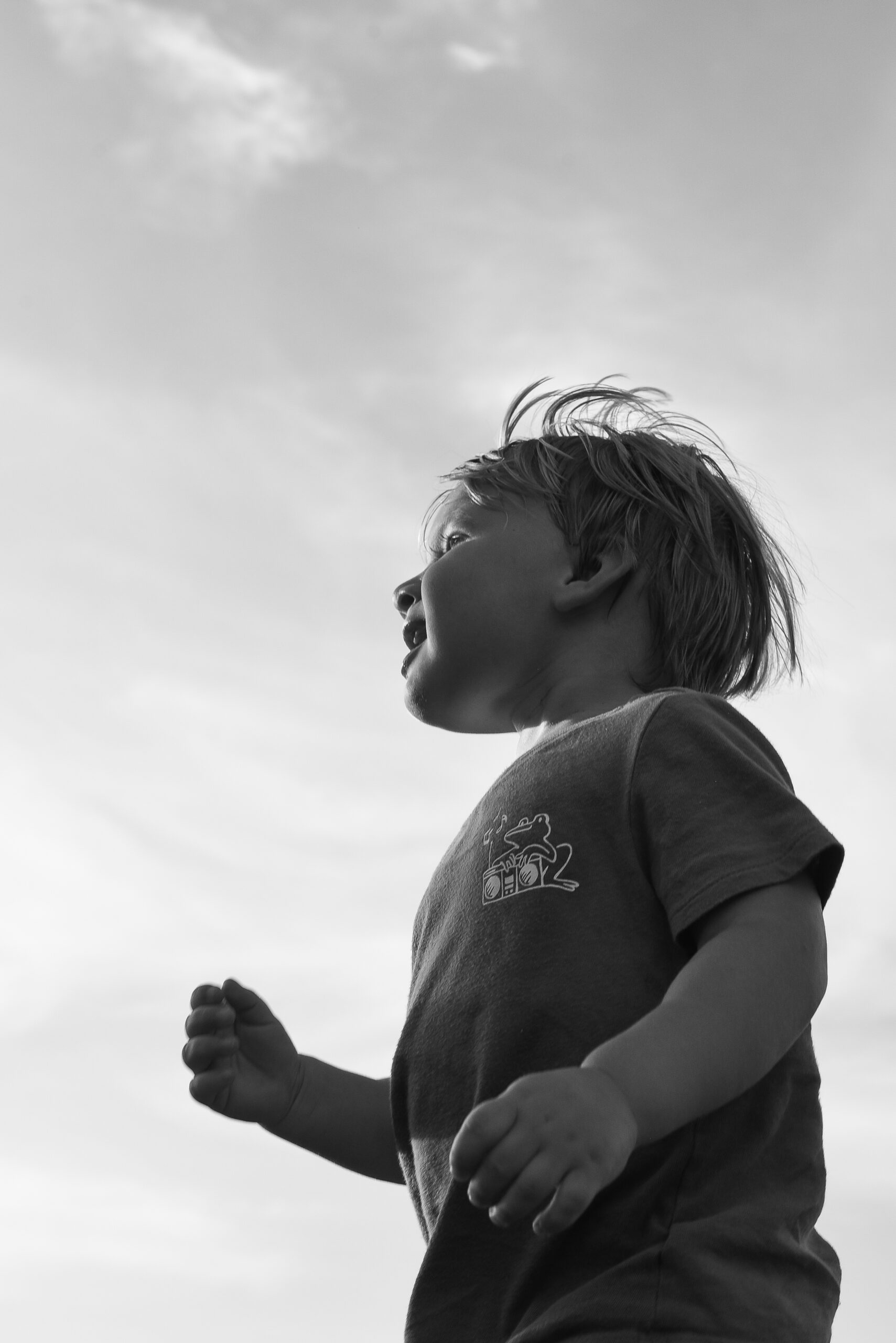 Young boy runs wildly during a documentary photo session on a playground in Fort Worth