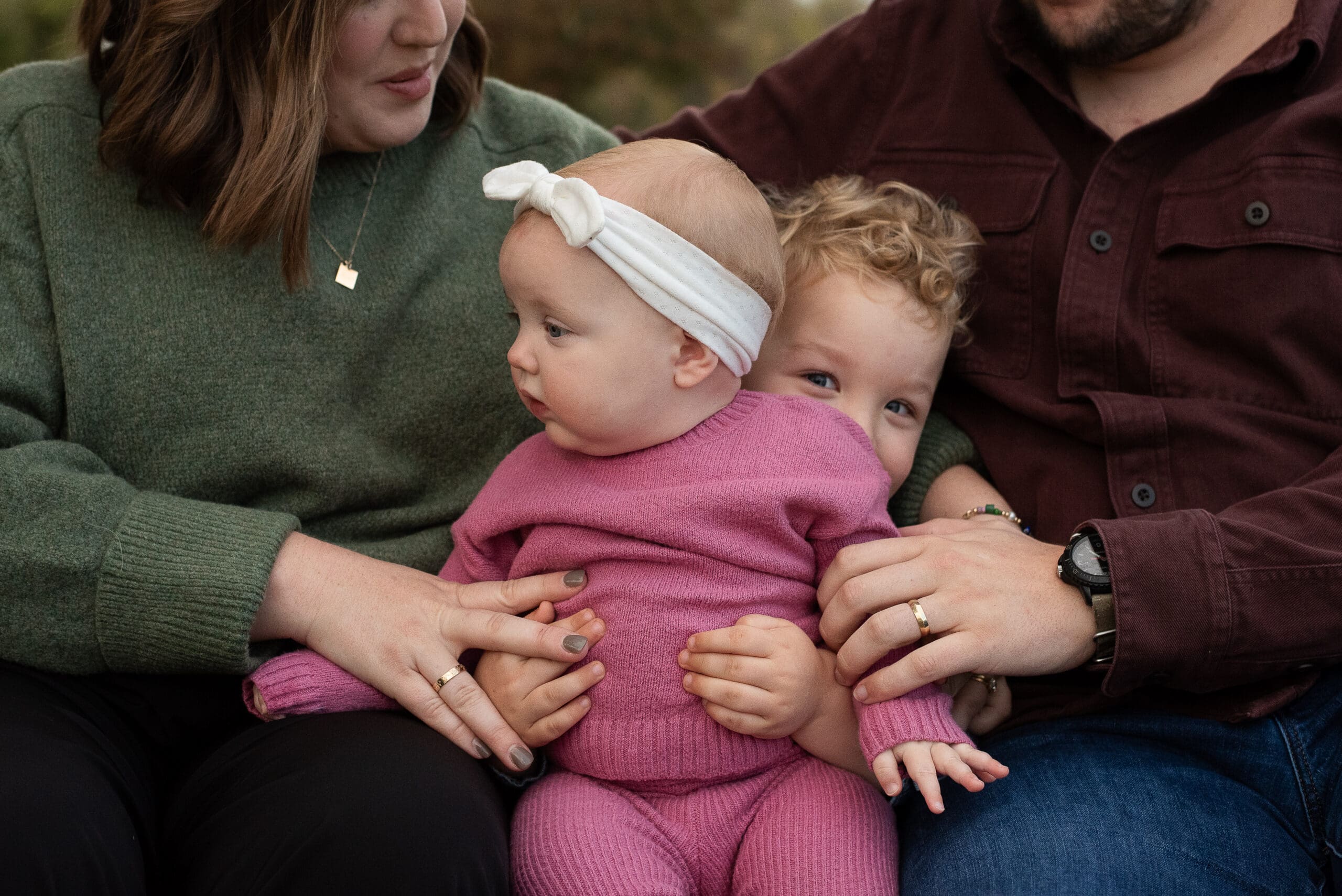 Young toddler pokes his head around little sister in family photos in Fort Worth, TX.